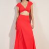 Model wearing a coral twist-front crop top with a matching high-waisted maxi skirt and pink flip-flops, standing against a light background.