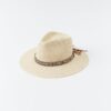 Beige straw sun hat with a multi-colored braided band on a white background.