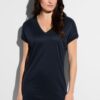Woman in a navy V-neck short-sleeve top against a light wall outside the frame edge of the image