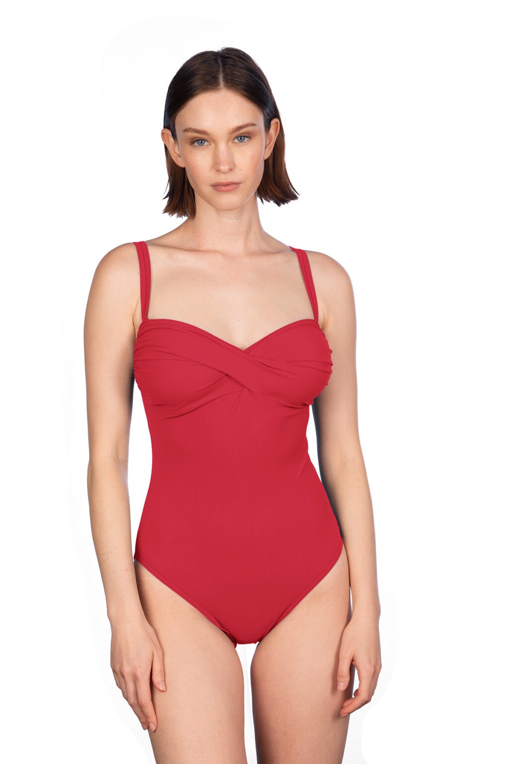 Woman in a red one-piece swimsuit with a twisted front, standing against a white background.