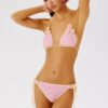 Woman modeling a pink crochet bikini with cream edging and flower appliques.